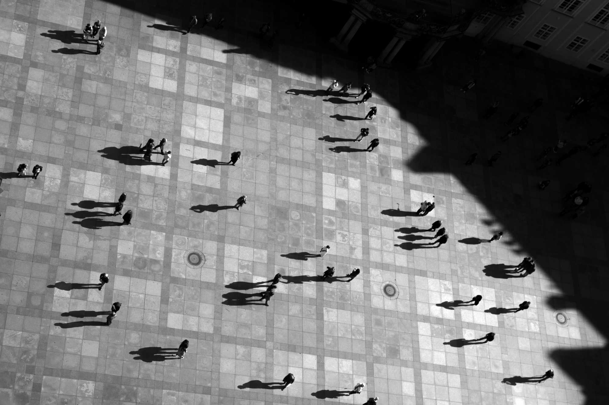 Top-down drone shot of people crossing a square
